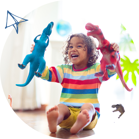 Happy child playing with toy dinosaurs