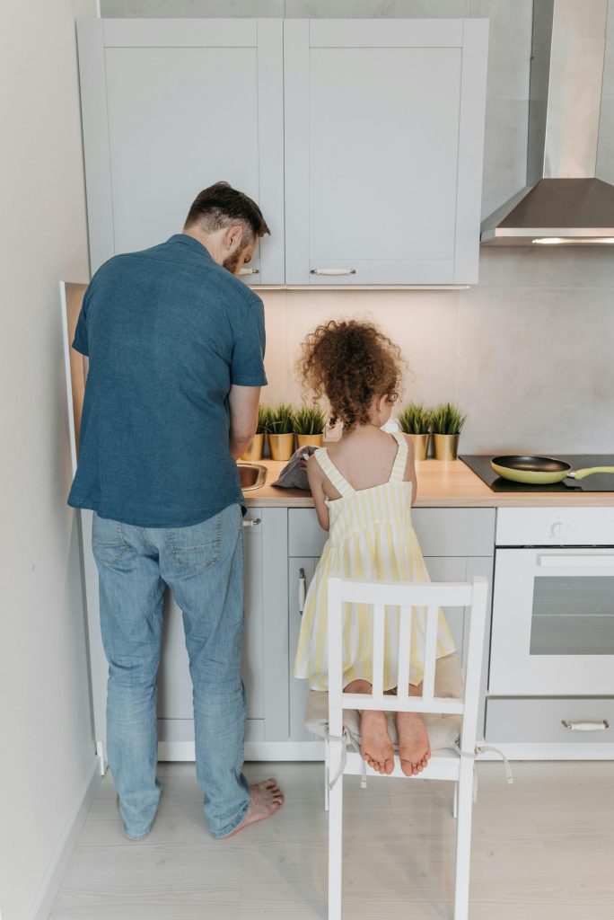 Father teaching daughter to cook in the kitchen